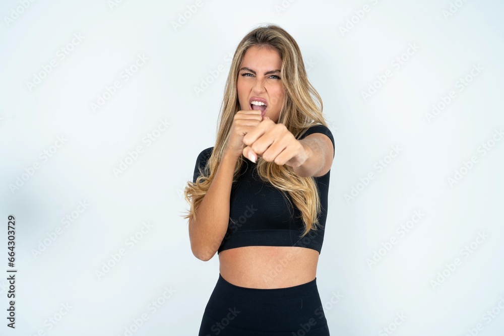 caucasian woman wearing sport clothes Punching fist to fight, aggressive and angry attack, threat and violence caucasian woman wearing sport clothes Punching fist to fight, aggressive and angry attack, threat and violence
