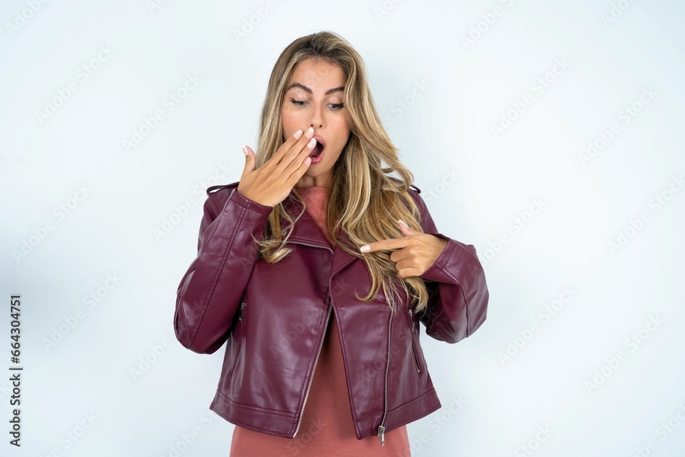 Shocked Young beautiful woman look surprisedly down, indicates at blank with fore finger, Scared model Shocked Young beautiful woman look surprisedly down, indicates at blank with fore finger, Scared model