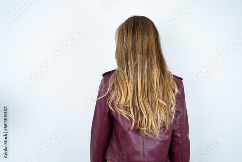 The back view of a Beautiful caucasian woman wearing leather jacket . Studio Shoot.