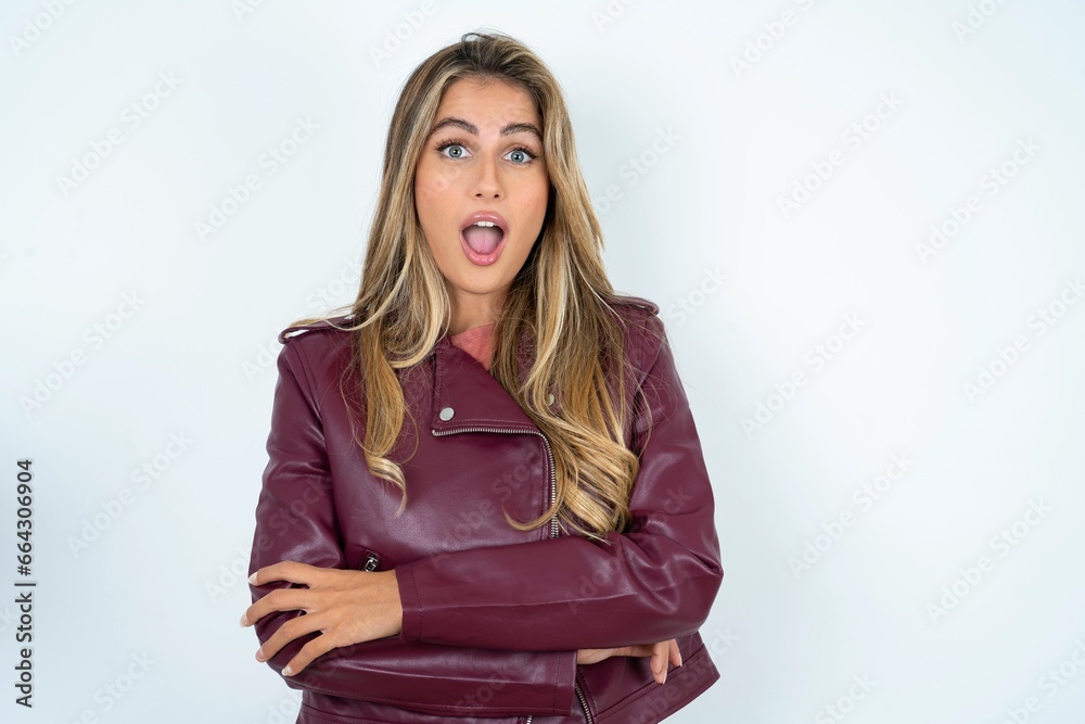 Shocked embarrassed Beautiful young woman wearing jacket keeps mouth widely opened. Hears unbelievable novelty stares in stupor Shocked embarrassed Beautiful young woman wearing jacket keeps mouth widely opened. Hears unbelievable novelty stares in stupor
