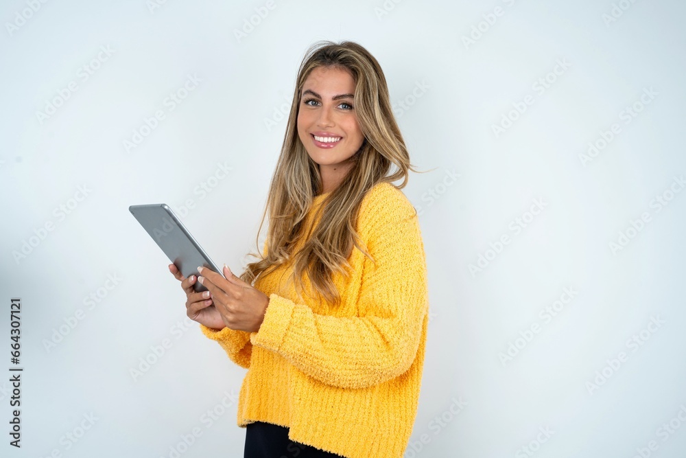 Photo of optimistic Young business woman wearing yellow sweater  hold tablet