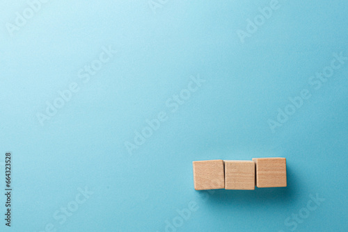 wooden cubes three pieces in a row on a blue background