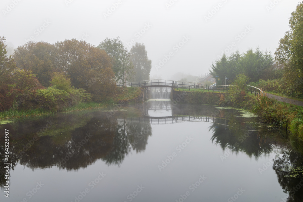 A canal lock gates on the Forth the Clyde canal on a cold and misty winter in Glasgow Scotland A canal lock gates on the Forth the Clyde canal on a cold and misty winter in Glasgow Scotland