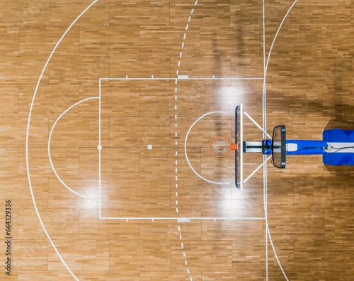 Top view of a basketball hoop and the restricted area (the key) with a foul line (free throw lane) on a parquet basketball court photo