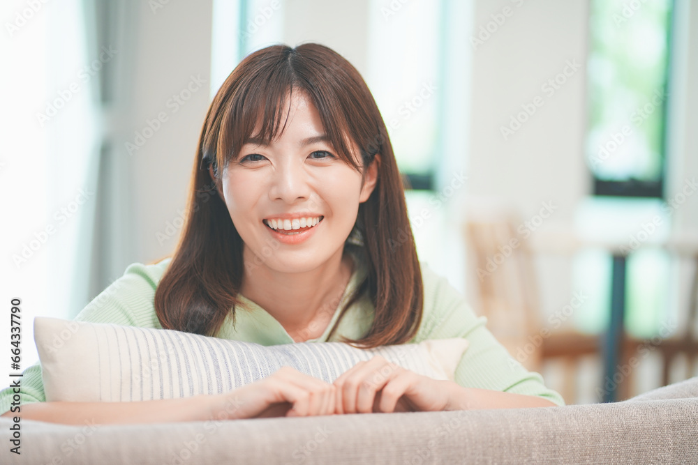 リビングのソファでくつろぐ笑顔の女性 リビングのソファでくつろぐ笑顔の女性