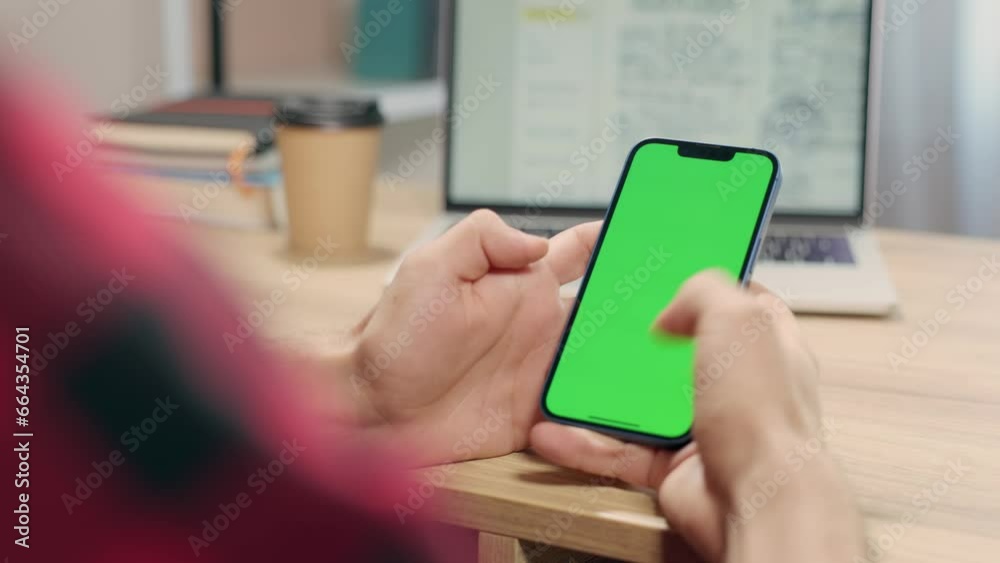 Man Using Smartphone in Vertical Mode with Green Mock-up Screen, Doing Swiping, Scrolling Gestures. Internet Social Networks Browsing News, Financial Reports Man Using Smartphone in Vertical Mode with Green Mock-up Screen, Doing Swiping, Scrolling Gestures. Internet Social Networks Browsing News, Financial Reports