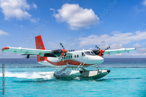 Exotic seascape seaplane on Maldives sea landing. Vacation or holiday luxury travel transportation in tropical popular destinations. Airplane flight and landing on calm ocean bay photo