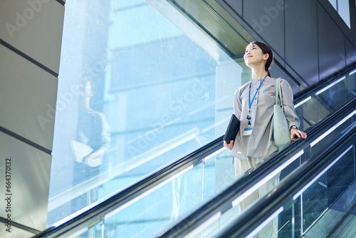 エスカレーターに乗る日本人ビジネスウーマン