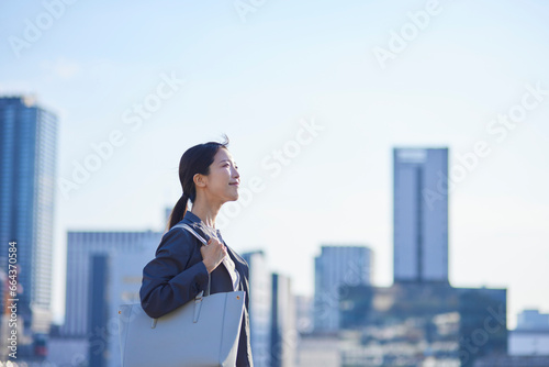 ビジネス街にて遠くを見つめる日本人ビジネスウーマン