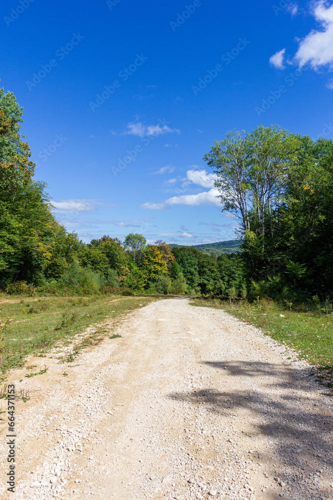 Late autumn, dirt road, nature walks, mountain panorama and hiking trails, warm autumn weather.