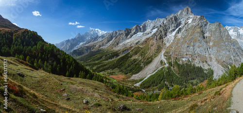 The panorama of Val Ferret, one of the Italian valleys that directly overlook Mont Blanc, during an autumn morning, near the town of Entreves, Valle d'Aosta, Italy - 2 October 2023. photo