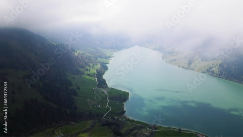 panoramic aerial view of beautiful idyllic Swiss lake with reflective surface and dramatic cloud formations in the Swiss Alps featuring Swiss sceneries, Waggitalersee and Innerthal in Switzerland     photo