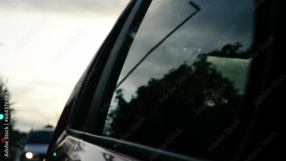 Driving through urban street through view of car wing rear mirror Driving through urban street through view of car wing rear mirror