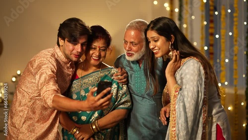 Indian family happily waving and chatting on a video call during Diwali celebrations, colourful decorations.a Hindu festival,diwali festival.standing toghter. photo