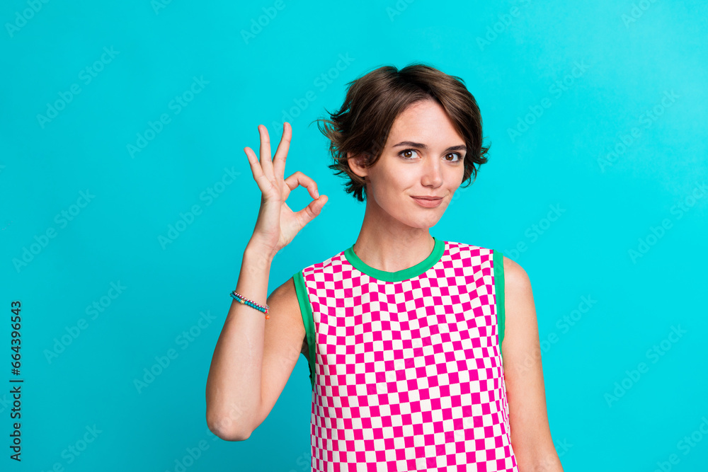 Photo of satisfied cheerful girl wear plaid stylish clothes hands demonstrate okey symbol nice feedback isolated on cyan color background Photo of satisfied cheerful girl wear plaid stylish clothes hands demonstrate okey symbol nice feedback isolated on cyan color background