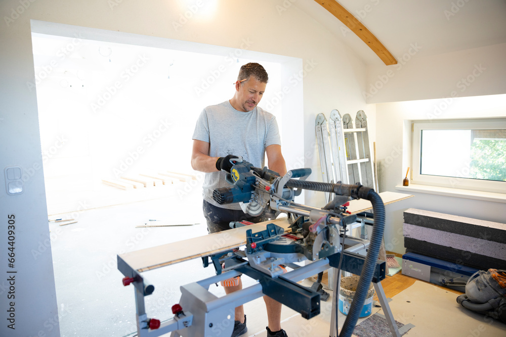 middle-aged man with gray hair glued, laying parquet floor in my loft apartment, top floor middle-aged man with gray hair glued, laying parquet floor in my loft apartment, top floor