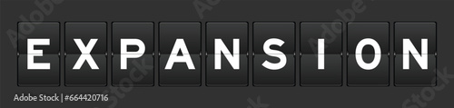 Black color analog flip board with word expansion on gray background