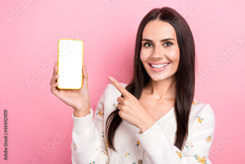 Photo of young attractive girl model electronic device advertisement pointing finger interface website isolated on pink color background