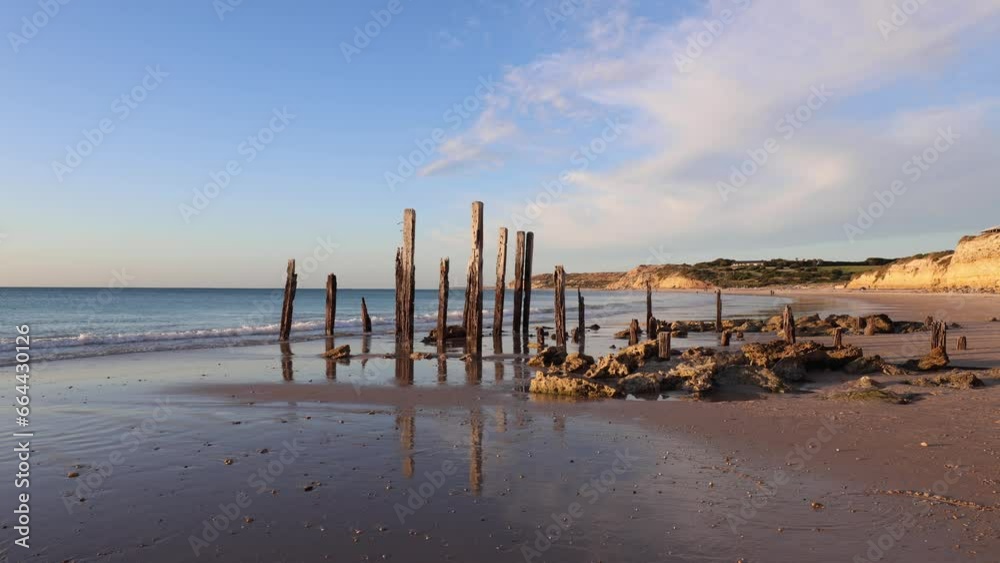 Reflection of wooden jetty remains on the beach coastline. Reflection of wooden jetty remains on the beach coastline.