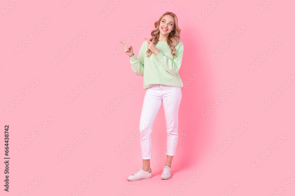 Full body portrait of gorgeous cheerful lady look direct fingers empty space isolated on pink color background Full body portrait of gorgeous cheerful lady look direct fingers empty space isolated on pink color background