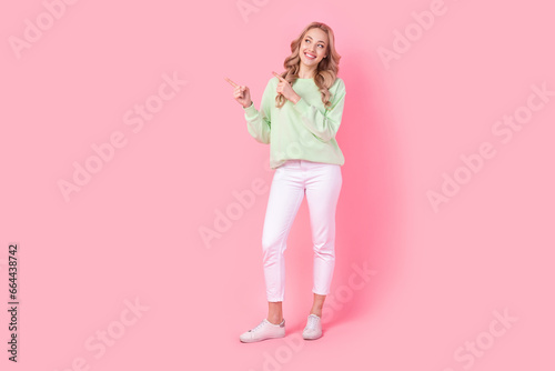 Full body portrait of gorgeous cheerful lady look direct fingers empty space isolated on pink color background