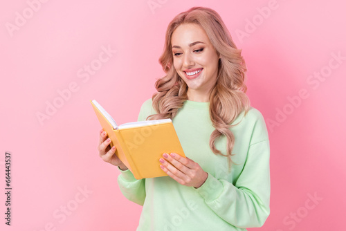 Portrait of cute cheerful person toothy smile hold read opened book isolated on pink color background