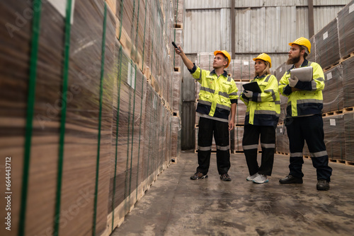 Warehouse staff verify wooded pallets items using handheld device, ensuring precise shipment.