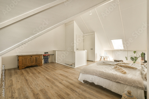 a bedroom with wood flooring and white walls in an attic - style home that has been used for many years