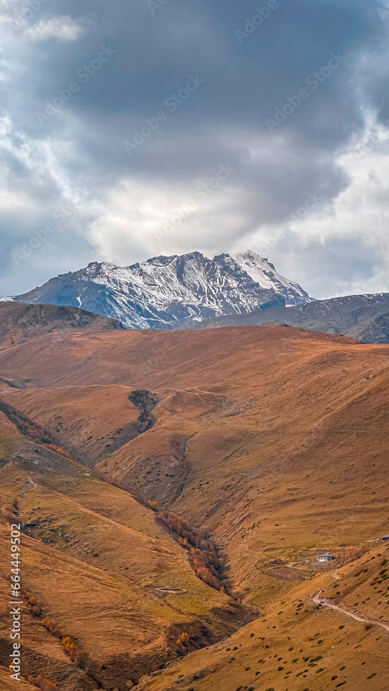 View of kazbegi mountains and monastery and peace statue of georgia and russia