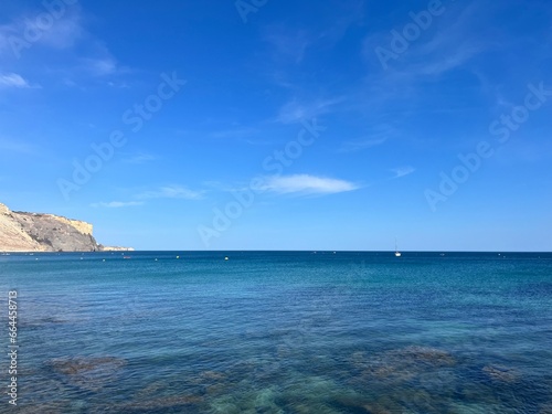 Fototapeta Naklejka Na Ścianę i Meble -  Transparent blue sea water, ocean bay, rocky coast, blue sky