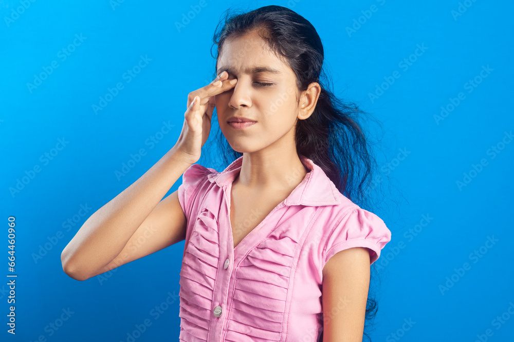 An Indian girl suffering from eye irritation and rubbing it An Indian girl suffering from eye irritation and rubbing it