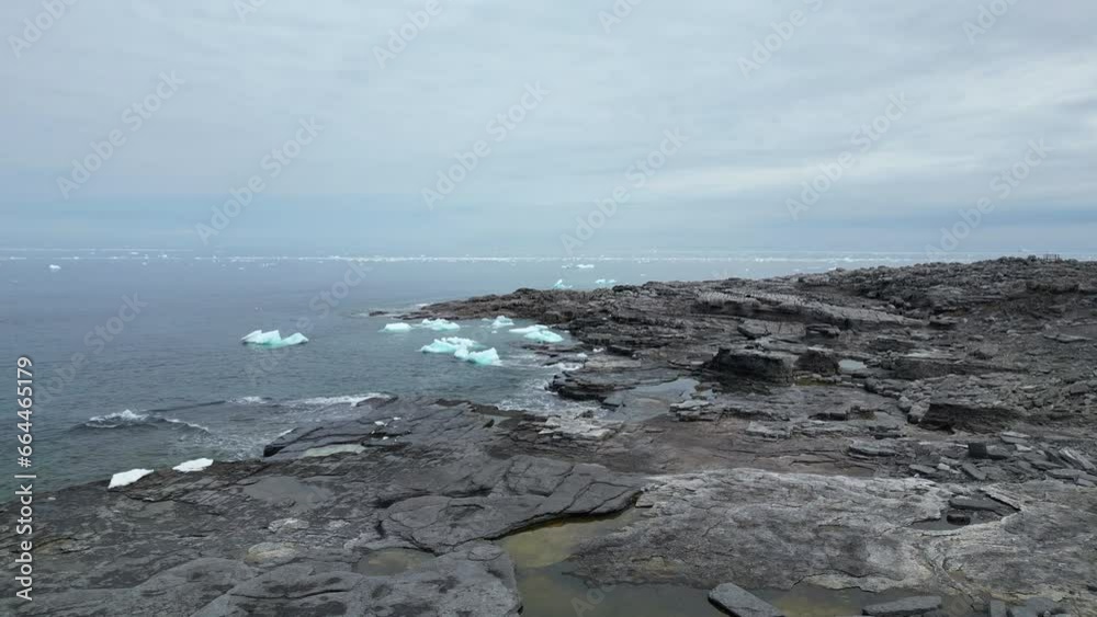 A captivating view of Cape Norman, showcases floating ice against a backdrop of intricate rock formations and the vast ocean horizon. A captivating view of Cape Norman, showcases floating ice against a backdrop of intricate rock formations and the vast ocean horizon.