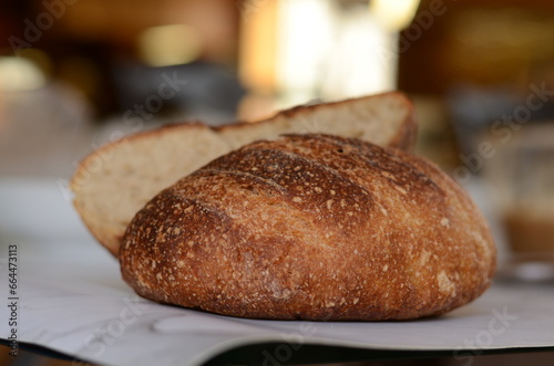 Freshly baked pretty loaf of homemade delicious sourdough bread sliced open on table/counter 