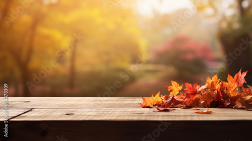 An wooden table with a softened Fall backdrop  including reddish-yellow foliage.
