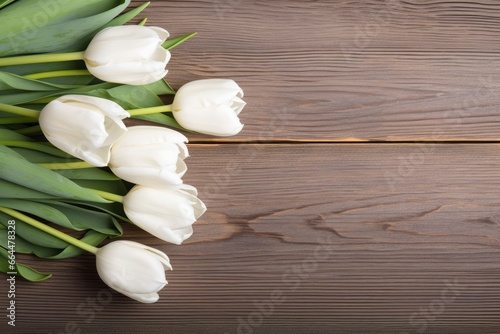 White tulips on wood table.