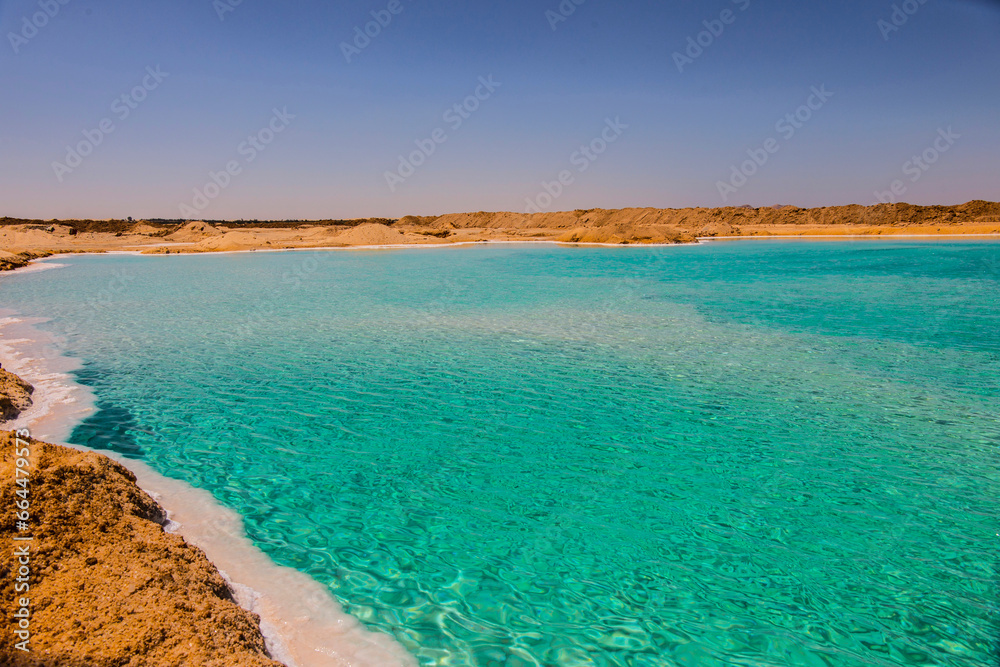 Obraz premium Salt lake with turquoise water and white salt on the shore near Siwa oasis, Egypt
