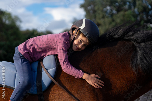 A child hugging a horse smiling