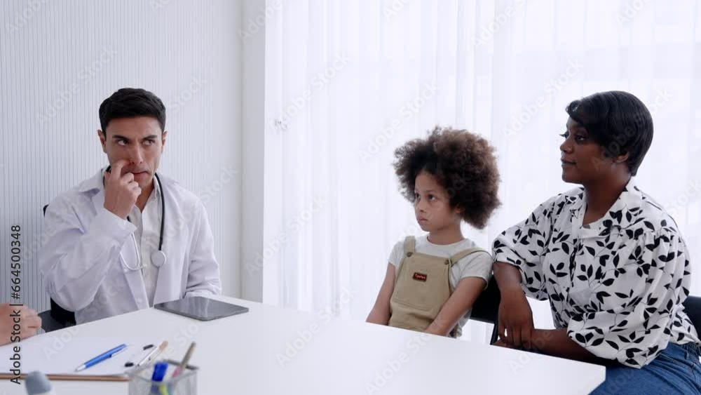 African mother and sick daughter come to pediatrician. Listen to a senior female medical expert nearing retirement age. Explain the symptoms and have a Hispanic Caucasian doctor available to advise. African mother and sick daughter come to pediatrician. Listen to a senior female medical expert nearing retirement age. Explain the symptoms and have a Hispanic Caucasian doctor available to advise.