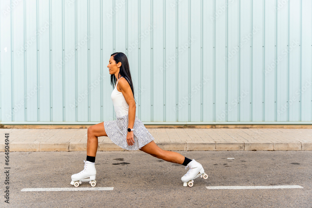Happy middle aged woman wearing dress smiling while rollerblading asphalt road in sunny day Happy middle aged woman wearing dress smiling while rollerblading asphalt road in sunny day