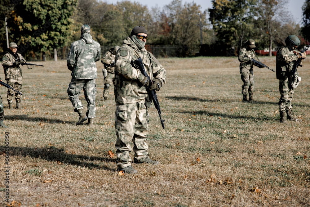 Soldiers in formation. Soldiers with a machine gun in military uniform. Special forces with weapons take part in a military maneuver. War, army, equipment and the concept of people. Camouflage. Traini