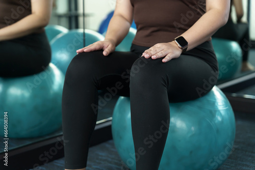 Sporty woman exercising on ball fitness workout and health concept. training working out and sitting on gymnastic fitball at gym
