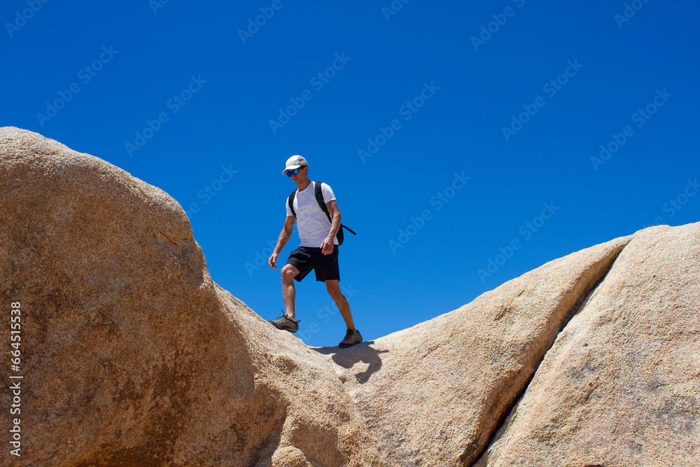 Man walks on the edge of the rock.Destination and exploring. Arch Rock Trail, Joshua Tree National Park, California, USA