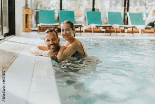 Foto Young couple relaxing in the indoor swimming pool