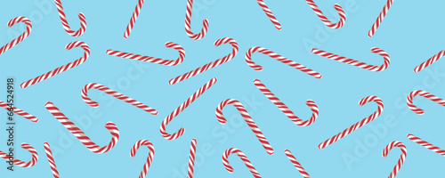 Many candy canes on light blue background. Pattern for design