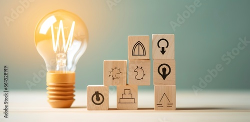 Creative idea, solution and innovation concept. Idea generation for business development. Wooden cube blocks with light bulb and cycle icons on clean background and copy space.