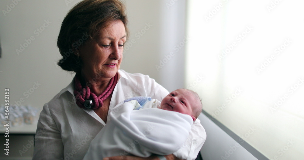 Grand-mother holding newborn baby infant grand-son