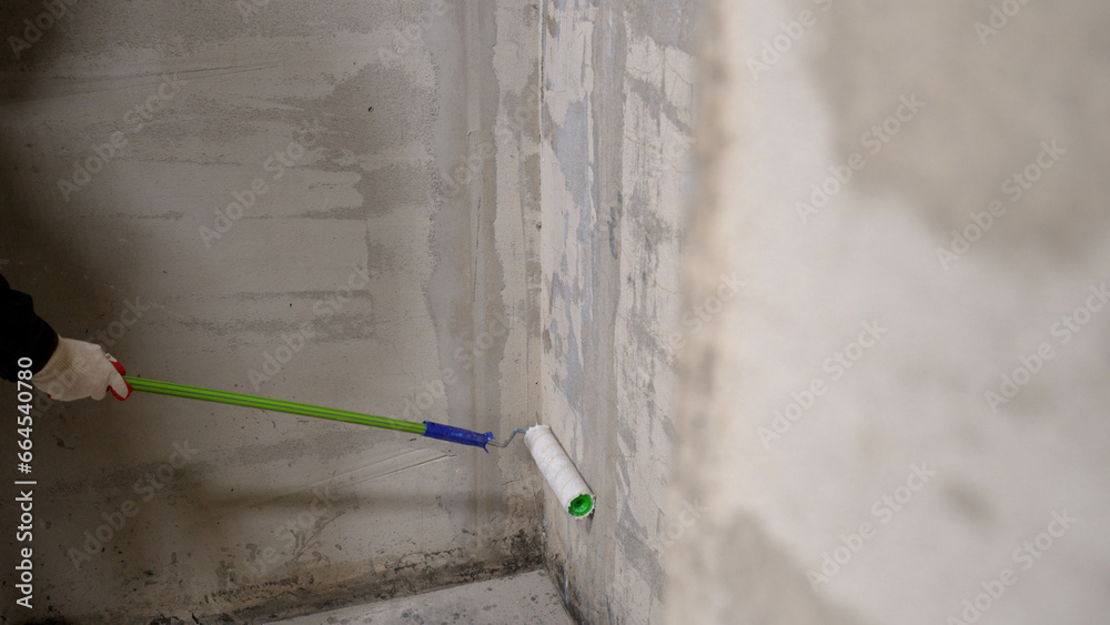 Roller brush with primer for plastering walls. Concept of building a