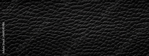Seamless dark black leather background pattern. Tileable closeup textile texture of soft plush luxury cow hide or other creature or animal skin. A high resolution fashion backdrop