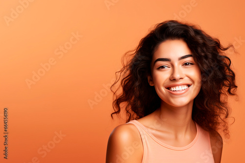 a female model, looking at camera, light orange background with copy space
