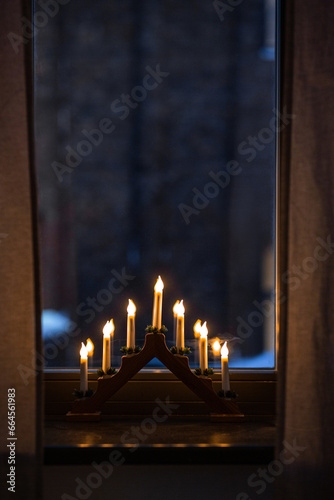 winter holidays and celebration concept - advent candlestick on window sill at night